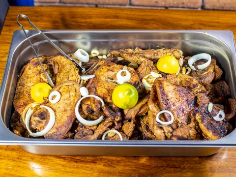 A tray of grilled fish and chicken with lemon and onion