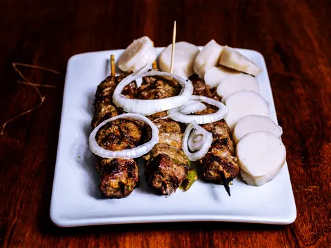 Grilled meat skewers with onion and cassava